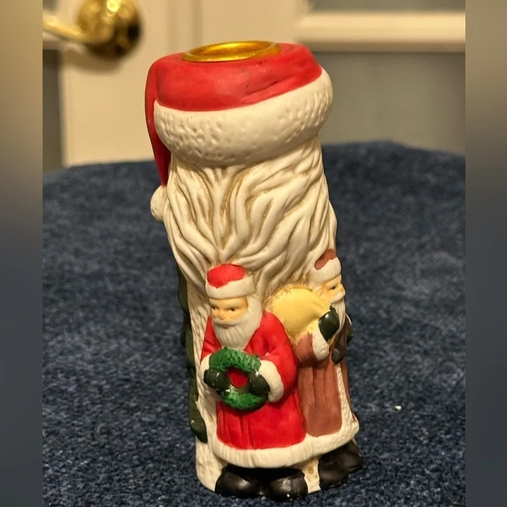 Set of 2 Santa candleholders. Each has smaller different smaller Santas.